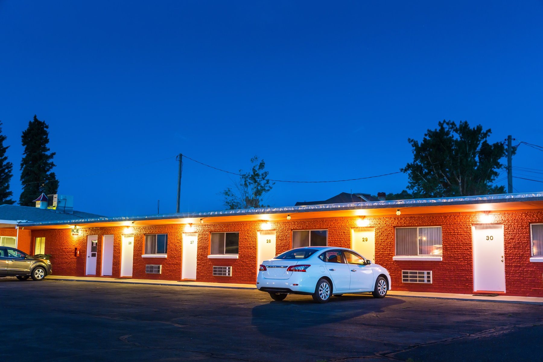 An American roadside hotel lit up at dusk